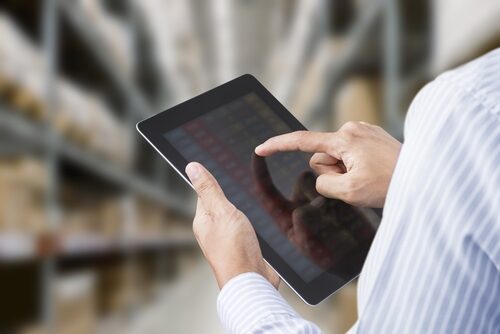 A warehouse employee implementing the issue tracker module on their tablet